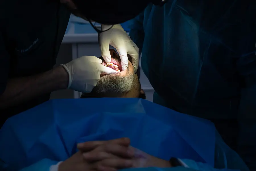 La bouche ouverte maintenue par les écarteurs pendant l’intervention