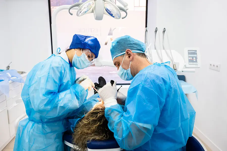 Deux cliniciens opérant, vus depuis la tête du patient