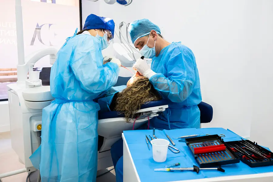 Deux chirurgiens au travail, le plateau d’instruments au premier plan