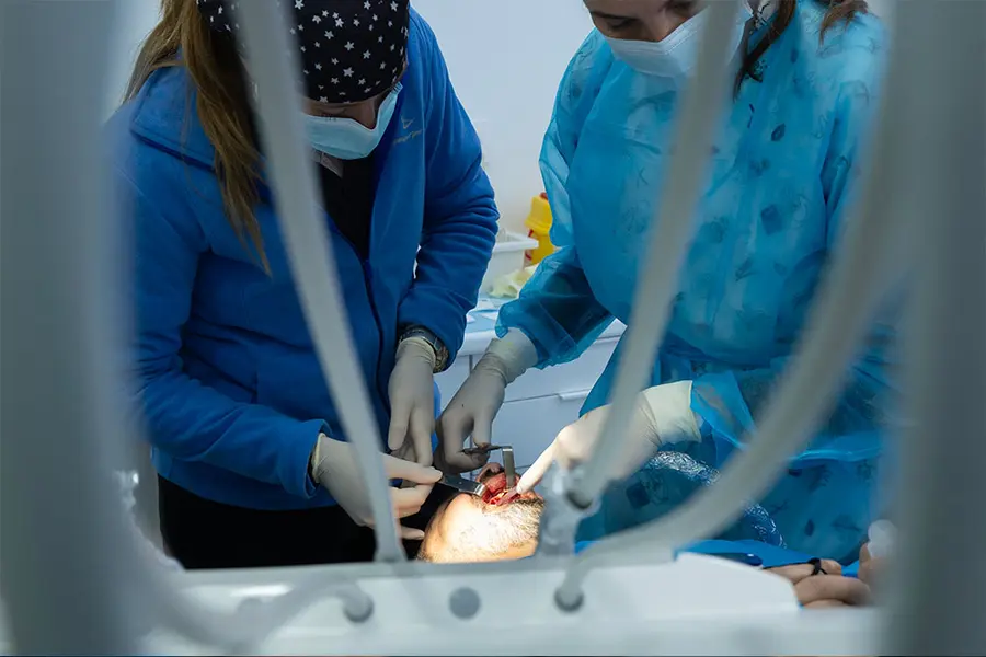 Deux cliniciens penchés sur le patient, vus depuis l’appui-tête